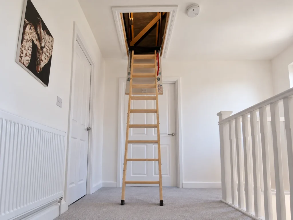 Timber folding loft ladder fitted through a ceiling hatch on a landing